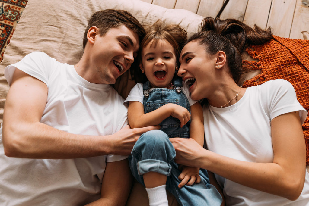 Father, child and mother laughing together. Parental rights are guaranteed.