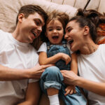 Father, child and mother laughing together. Parental rights are guaranteed.