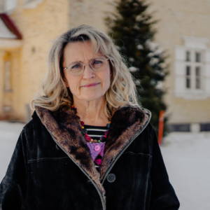 Päivi standing outside smiling in her native Finland