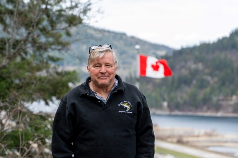 Jim Demers standing with the Canadian flag in the background.