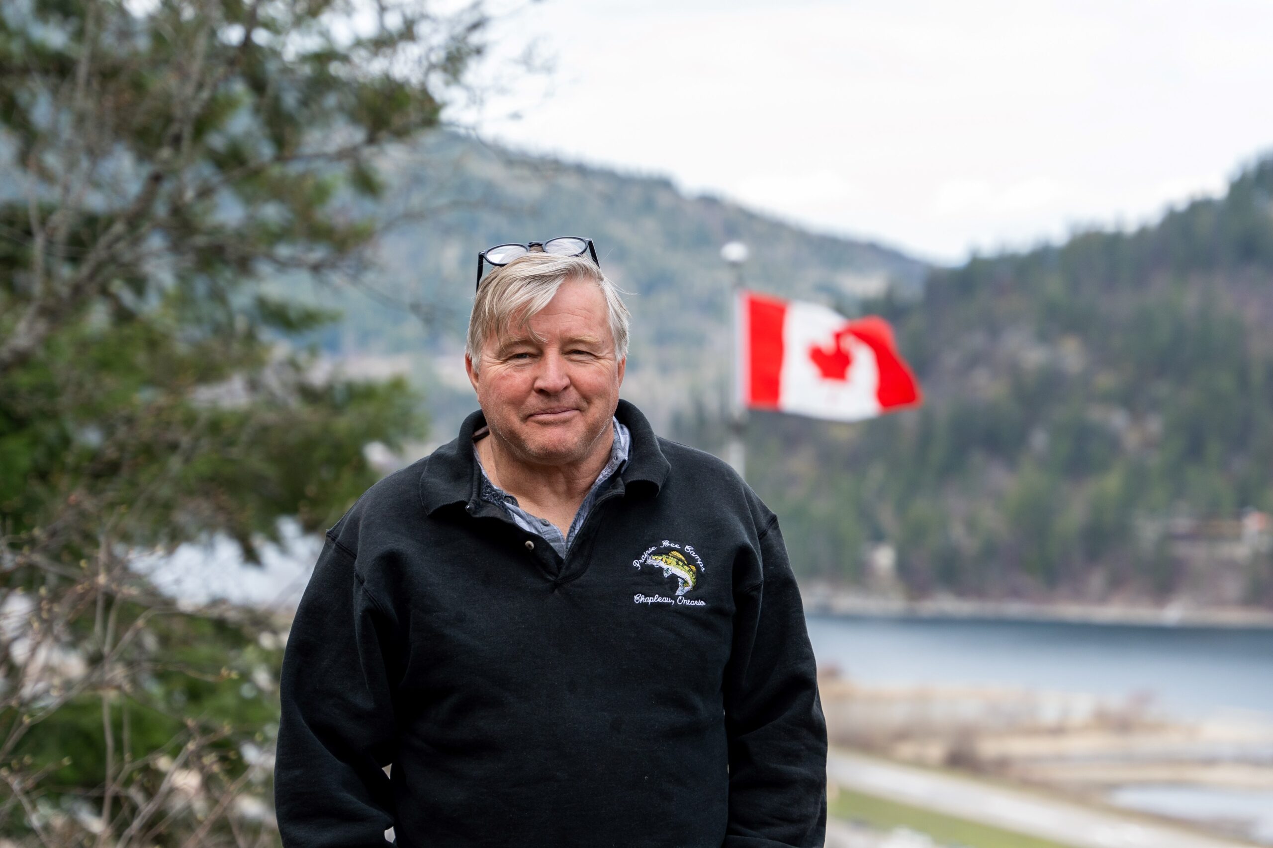 Jim Demers standing with the Canadian flag in the background.
