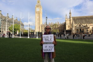 Livia stands alone with her sign in London.